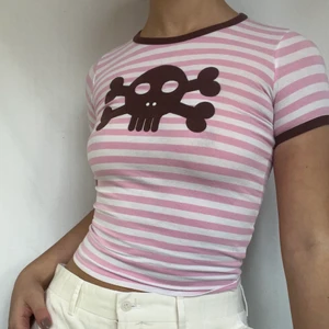 Babytee - Randig babytee med brun döskalle! Jag på bilden bär oftast S men den passar även xs! Köpare står för 26kr frakt. Plagget är o gott defektfritt skick. 