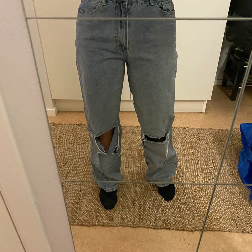 Jeans från Boohoo i storlek 36. Jeansen har stora hål och slitningar nere vit byxbenet. . Jeans & Byxor.