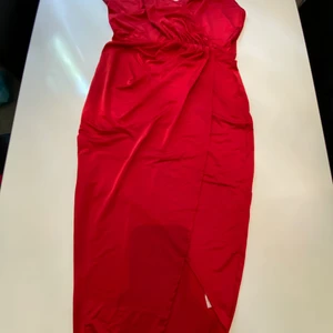 Röd klänning  - Röd klänning från Nelly, längre baktill o kortare fram. Samt v ringad