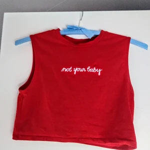 Röd topp - En röd liten topp från H&M                                               trycket är vitt och det står "Not youre baby"