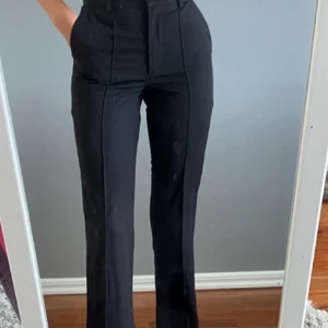 Kostymbyxor med slits - Säljer mina kostymbyxor som blivit för kort på mig som är 171cm. Två fickor fram och två fakefickor bak. Strl 32 Från Nakd. Frakt 72kr