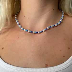 Blue ocean - Jättefint handgjort halsband i tre olika nyanser av blå färg samt med vita stora pärlor💙 perfekt till ett par blåa jeans eller bara ett vitt linne för att stylea upp outfiten 💙tråden är elastiskt samt att det tillkommer spänne vilket gör att halsbandet är justerbart 💙🤍