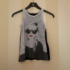 Linne - Ett svart linne med tryck på framsidan och spets på baksidan.