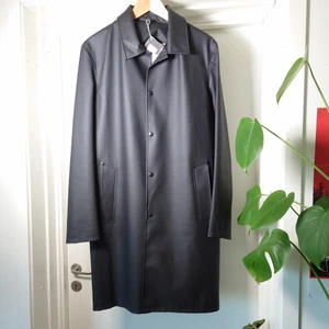 Stuttenheim regnkappa - En svart regnkappa från Stutterheim i klassisk modell. Den är helt ny och oanvänd med prislapparna kvar. Har kostat 2695kr. Alltså mindre än halva priset. Storlek M, funkar även på S🌻