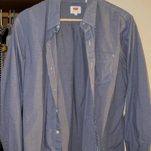 Levi’s skorta - En ljusblå levi’s skjorta som har små vita rutor på sig! herr modell men haft den som en oversize skjorta! Super snygg 