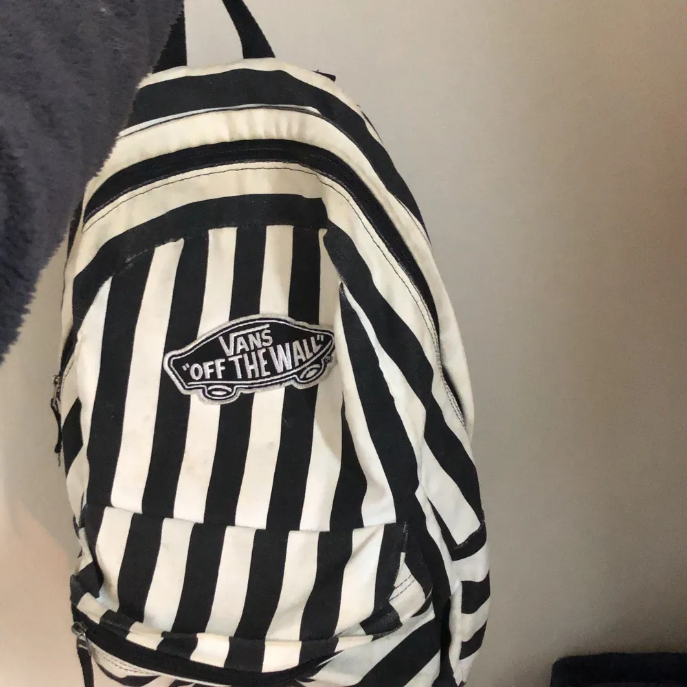 En ryggsäck från märket Vans. Svartvit och randig ryggsäck med ett stort och ett litet fack. . Väskor.