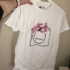 Vit T-shirt med tryck. - Vit t-shirt med tryck ”Chanel”. Oanvänd.