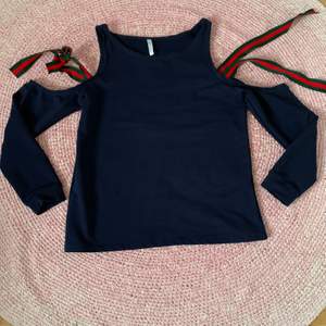 Cold shoulder marinblå tröja med flerfärgade band som kan knytas. Storlek S/M. Använd en gång. 
