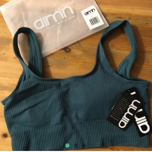 A’imn sport-bh - Helt ny aim’n sport-bh! Ribbad och seamless i färgen hydro. En present som är för stor så den är enbart provad en gång. Lappar och förpackning finns kvar. Nypris 349kr, köparen står för frakt. 