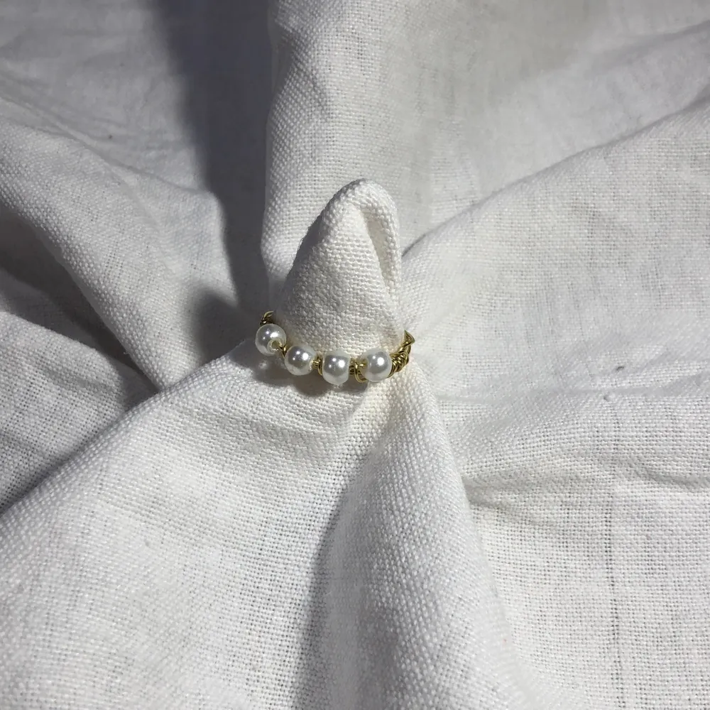 En hemmagjord ring med 4 vita pärlor på och metalltråden är i färgen guld. Passar bra till mycket. 61 med frakt 🚚 . Accessoarer.