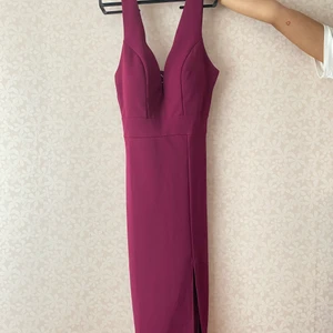 Plommonfärgad Klänning - UK 6 - Oanvänd knälång klänning från Wal G Petite, UK storlek 6. Den har vadderad bröst så den går utmärkt att ha utan bh. Luftig trikå tyg perfekt för sommaren. 