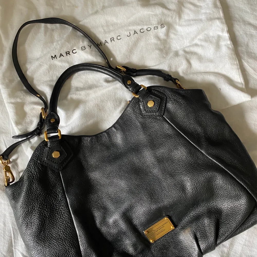 Marc by Marc Jacobs väska i modellen Classic Q Francesca. 100% läder och självklart 100% äkta   Haft i ca 5 år men otroligt bra skick då jag endast använt den ett fåtal gånger.  Två små sminkfläckar på fodret men inget som är supertydligt.  Ett dragkedjefack på ena sidan och två mindre tygfack på andra, kommer med axelremsband som man kan ta av.  Spänne på insidan av väskan som kan ändra väskans form och väskan stängs med magnet.  Dustbag medföljer. Köpt på raglady för 5 000 kronor. Fler bilder går att lösa och priset kan också justeras. Priset för frakten är inte 100% då jag inte vet hur stor som kan behövas. . Väskor.