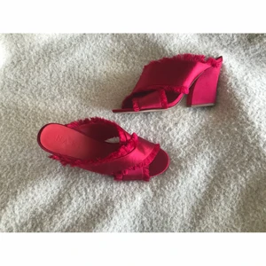 Röda satin högklackade festskor pumps slip-in NA-KD strl 39 - Röda satin högklackade festskor pumps slip-in NA-KD strl 39. En sömm har släppt lite upptill på vänstra skon (se bild) men ej så synligt eller trasig, annars i fint skick, använda endast ett par gånger.