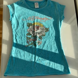 ED HARDY BLUE BEDAZZLED SUMMER TOP  - !!INTRESSEKOLL!!! Säljer endast vid bra bud med tanke på hur eftertraktad och ovanlig Ed Hardy är. Skriv pris ni är villiga att betala! Blå och fullt bedazzled summer top i väldigt bra skick! Storlek XS-S