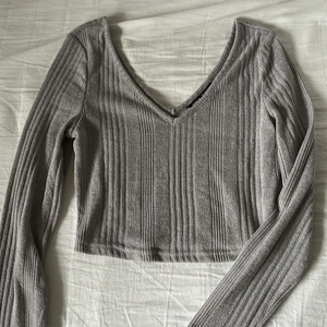 Ljusgrå v-ringad croppad topp strl S - Ljusgrå stickad, v-ringad croppad topp. Stretchig och skön i materialet! Storlek S, aldrig använd! 🥰