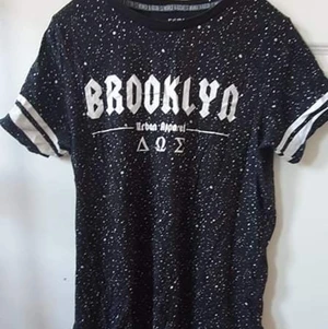Svart t-shirt  - Svart t-shirt med vita prickar och text storlek xs/s