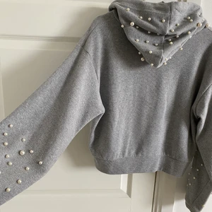 Grå hoodie med pärlor - Säljer en ball grå hoodie med vita pärlor i slutändan av armarna samt på luvan 🌟
