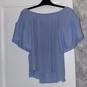 Topp  - Ljusblå topp, men lite små volanger 