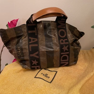 Fendi väska  - Liten väska med slitna detaljer. Säljer för att jag inte använder den. Höjd: 20 cm Längd: 35 cm Djup: 15 cm Kommer med dustbag 