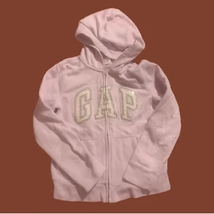Gap Hoodie - 💖Säljer nu min rosa Gap Hoodie eftersom jag knappt andvänt den. Hoodien är i stl 146-152 men sitter bra på någon med S/XS bara lite lite korta i ärmarna<3 Den är nästan som ny och inga synliga defekter. På märket är det lite rosa gulligt glitter 💖 