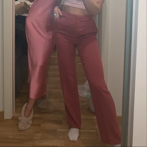 Knappt använda rosa byxor från hm - Perfekta kostymliknande byxor från h&m som är slutsålda!! de sitter som en smäck och är så bekväma. Har bara använt de en gång då de tyvärr blivit för små för mig :( har sytt ner de liite i benen så på bilden ser ni hur de sitter på mig som är 170. Säljer även likadana byxor i svart