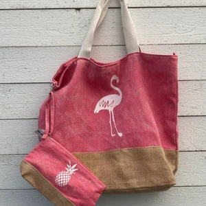 Trevlig strandväska  - Snygg rosa/beige/krämfärgad strandväska med tillhörande necessär. Trycken är flamingo på väskan och ananas på necessären