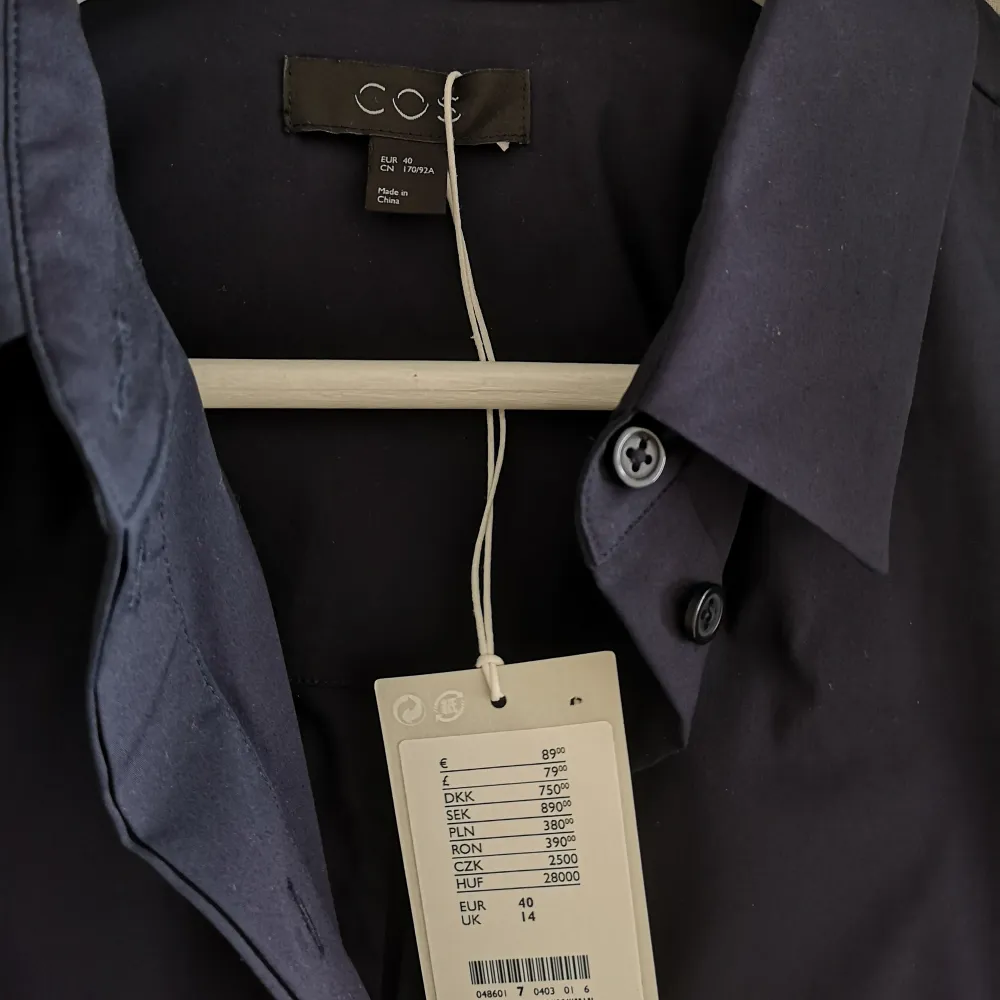 Mörkblå skjortkläning från COS. Fin kvalitet och fina fickor. Aldrig använd pga fel storlek. Ord pris 890 sek. Kjolar.