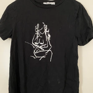 Svart t-shirt med en kvinnosiluett  - STORLEK: M | SKICK: Använd | Supersnygg T-shirt från NAKD med siluetten av en naken kvinna på. Använd men fortfarande väldigt fin⚡️⚡️