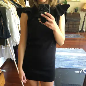 Black mini dress in sweat fabric with cut out back. Very short and sexy dress but still casual because of the fabric. 