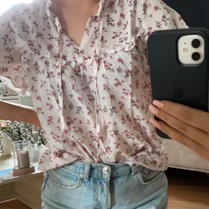 Söt blommig topp stl.S - Vit blommig topp med blommor och knytning, hur söt som helst men tyvärr lite stor på mig. Stl. S. Köparen står för frakt.