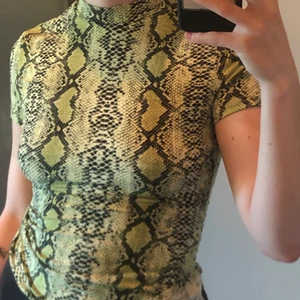 Snakeprint mock neck  - En grön T-shirt med halv polokrage. Aldrig använd. Väldigt skönt och tunnt material. 