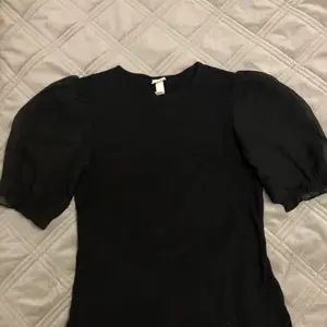 En svart kortärmad blus med puffiga armar i storlek S 