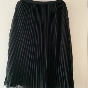 Svart plisserad kjol  - Svart plisserad kjol från Boohoo. Storlek 36, Verklig i storleken. Slutar vid nedanför knäna på mig som är 166cm. Använd fåtal gånger och är i bra skick. Kan mötas upp i Malmö & Vellinge, köparen står för frakten. 