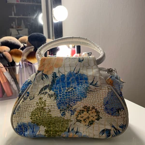 Handväska  - En supergullig handväska med fint sommar-mönster. Aldrig använd, säljs då den ej kommer till användning. Rymmer mycket. KAN FRAKTAS MEN KÖPARE STÅR FÖR FRAKT📦