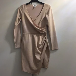 Beige V ringad kläning - Beige V ringad kläning med små ”volanger” på ena sidan. Använd en gång i storlek S