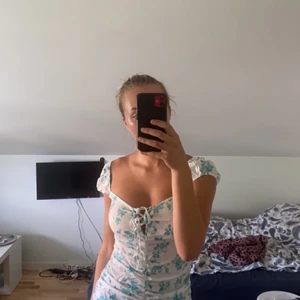 Vitblommig klänning med knyt i fram - Tajt modell, med lite puffärmar 