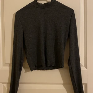 Croppad och långärmad tröja  - Ribbad och långärmad topp som har en krage som går till halsen. Den är i storlek 38 men om man har lite större byst sitter den lite tajtare. (Tredje bilden lånad) 