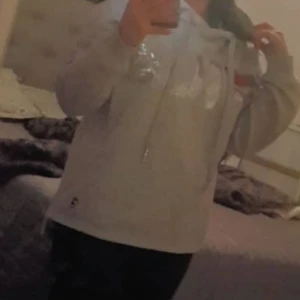 FILA HOODIE grå  - En fin fila hoodie med långa snören och fila text i röd samt silver och färg på tyget är i grå då jag har använd den ett par gånger och nu vill sälja.