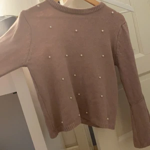 Stickad rosa tröja - Stickad tröja med pärlor, den har utsvängda armar.