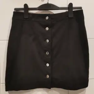 Svart kjol med silver knappar från H&M i storlek 42. Fint skick 🖤 Frakt tillkommer 💕