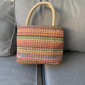 Super söt väska  - En supersöt färgglad väska som jag skulle sagt är i strand stil. Den är virkad på utsidan och har fake skin detaljer på insidan och botten. Tyvärr har den aldrig kommit till användning och därför säljer jag den vidare. Hör av dig om du vill ha fler bilder 🥰🌸