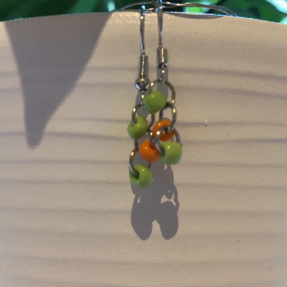 Ett par jättesöta pärlörhängen som passar sommaren jätte bra!🌻Färgen på pärlorna är grön och orange🌿🍂Är ungefär 1,5 cm.. Accessoarer.