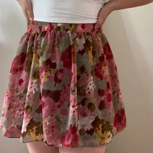 Blommig kjol från Indiska - Jättefin rosablommig kjol från Indiska. Nyskick, prislapp kvar. Storlek S men passar även XS och M.