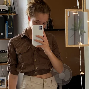 brun blus - brun blus med resår längst ner vilket ger en supersnygg passform!! fraktpris tillkommer🤩