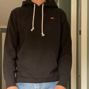 Levis hoodie - Mycket bra skick och har inga synliga fel. Storlek M, Modellen är 186 cm. Färg: Svart. Om du vill ha måtten på hoodien, DM. Säljer på olika plattformar