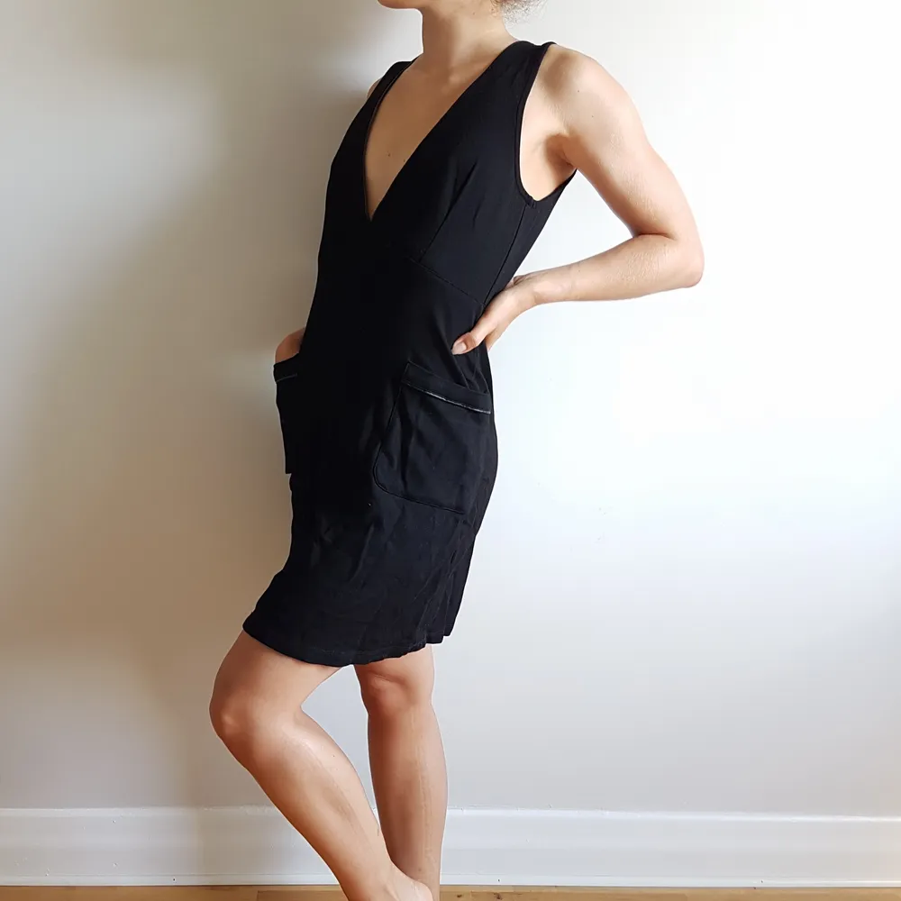 V-ringad svart fodralklänning av märket Busem, med fickor framtill. Stilren, enkel, klädsam. (Jag bär oftast stl:S så gör mitt bästa för att bära upp den). Klänningar.