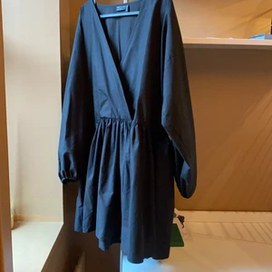 V-ringad klänning från ASOS  - Oanvänd svart klänning med omlott v ringning