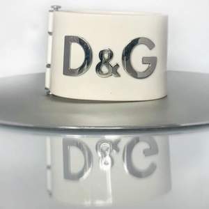 Authentic designer plastic bangle in off-white and silver from Dolce and Gabbana. 4,5 cm wide handcuff.