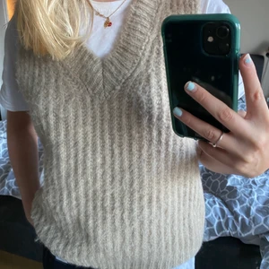 Väst  - Stickad väst i beige. Använd väldigt få gånger