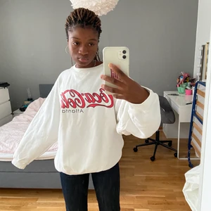 En vit sweatshirt med Coca-cola tryck.  - Sweatshirt i storlek s men väldigt står i storleken .